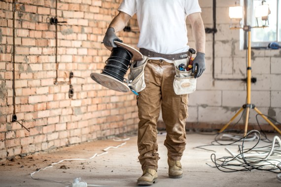 A man carrying the roll of wire